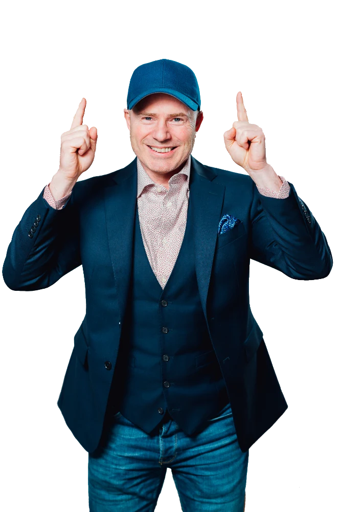 Mike Weiss in a blue cap and navy vest, pointing both index fingers up
